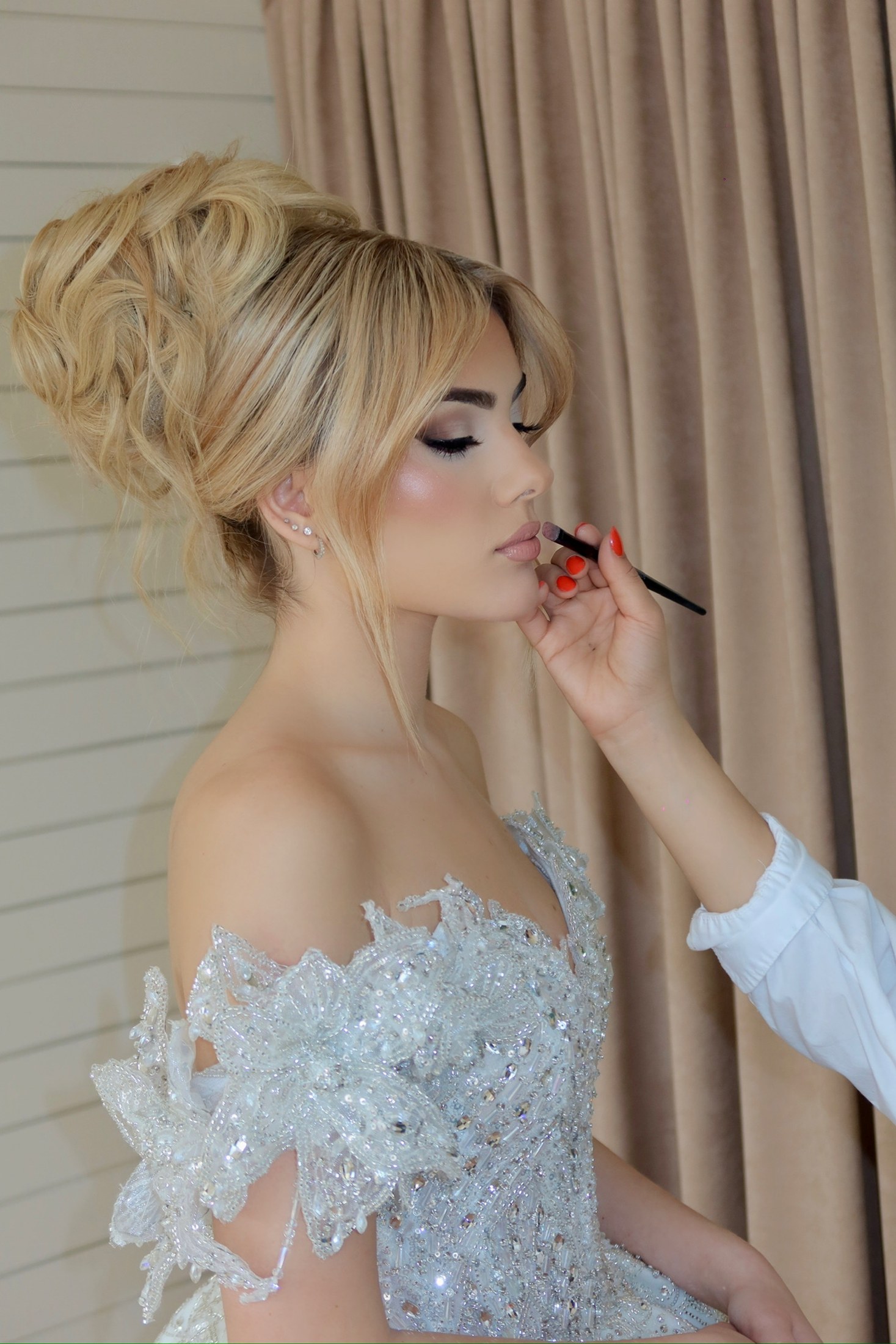 Charlize applying lip color to a bride